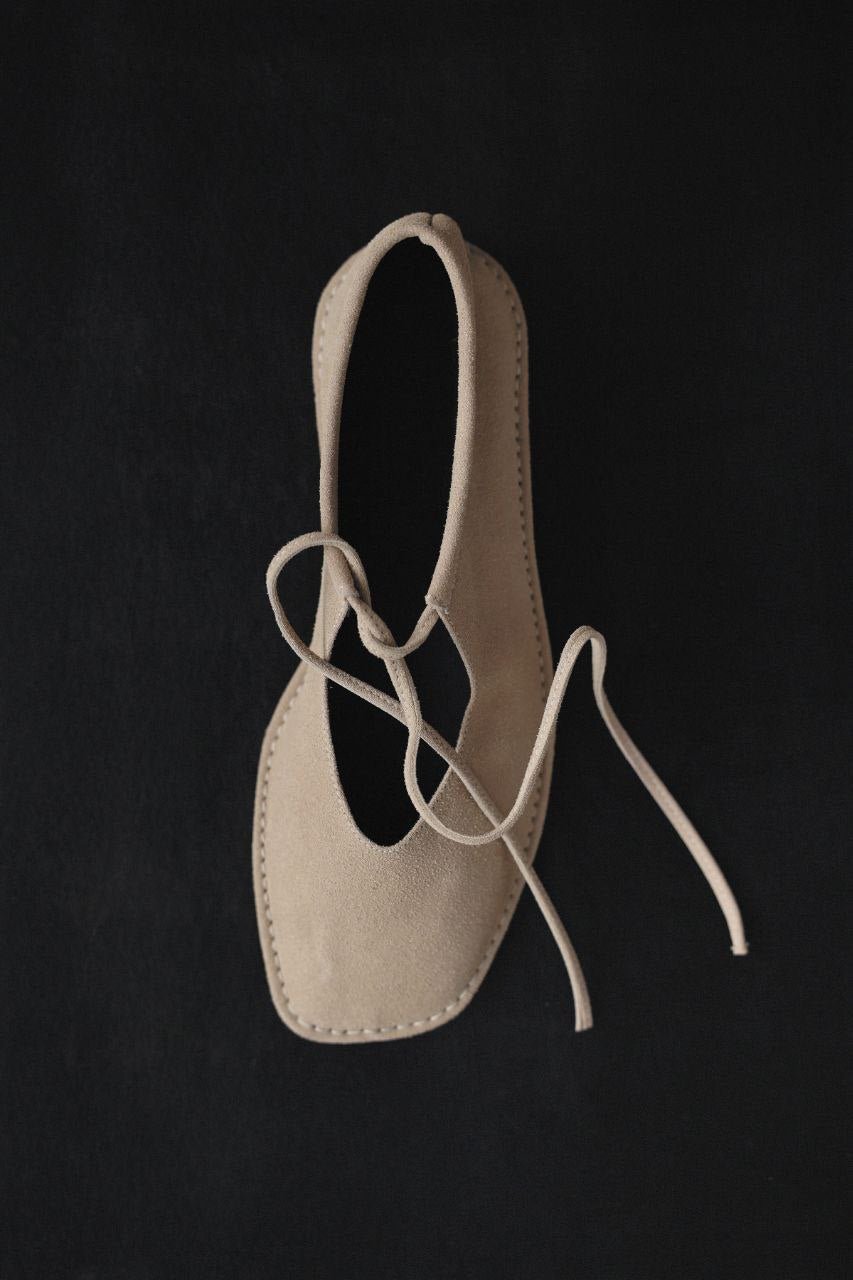 Beige suede ballerina shoes.