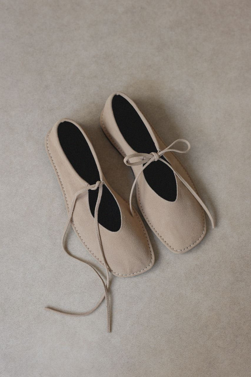 Beige suede ballerina shoes.