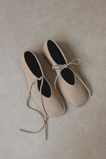 Beige suede ballerina shoes.