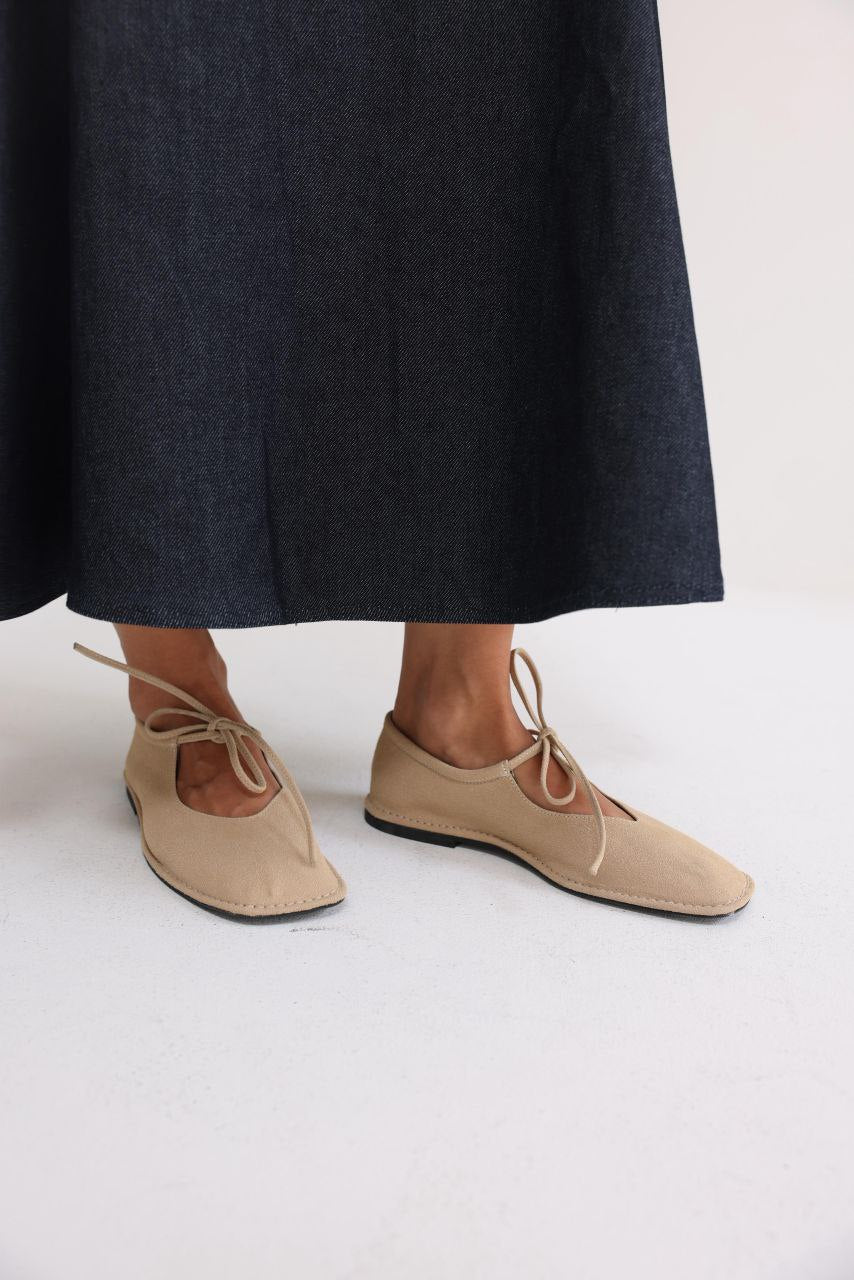 Beige suede ballerina shoes.