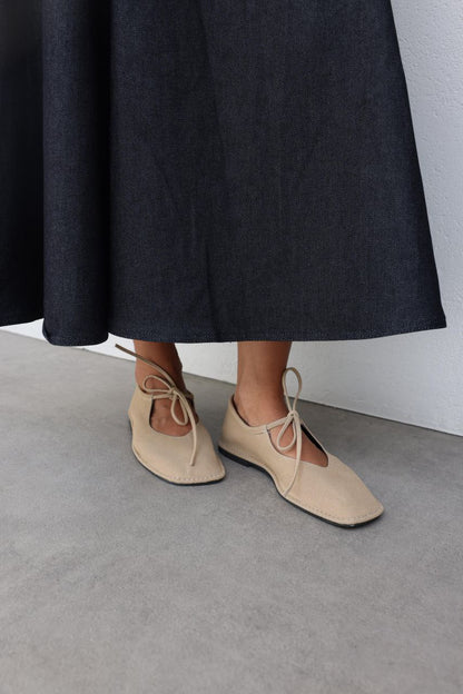 Beige suede ballerina shoes.