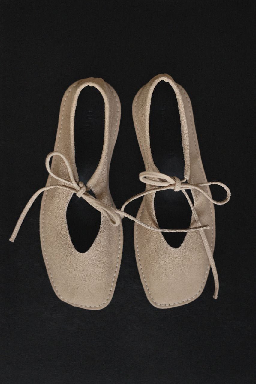 Beige suede ballerina shoes.